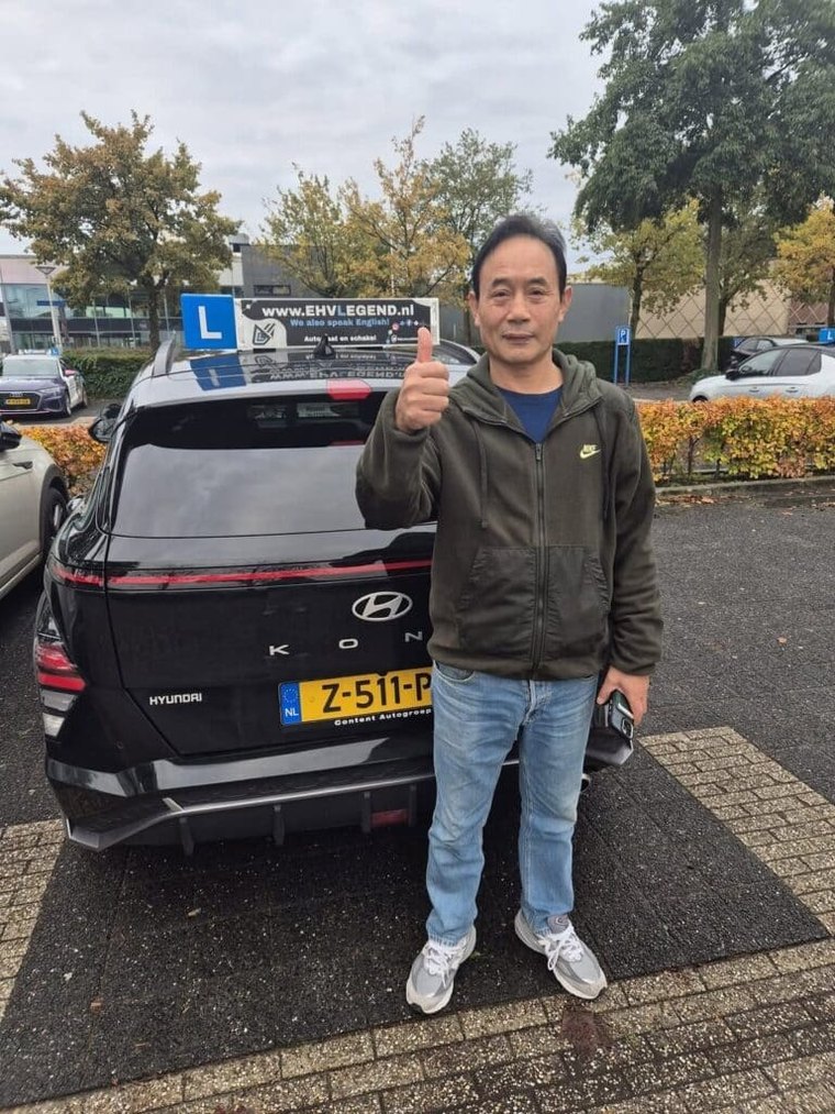 Geslaagde leerling met duim omhoog bij de Hyundai-lesauto van EHVLegend
