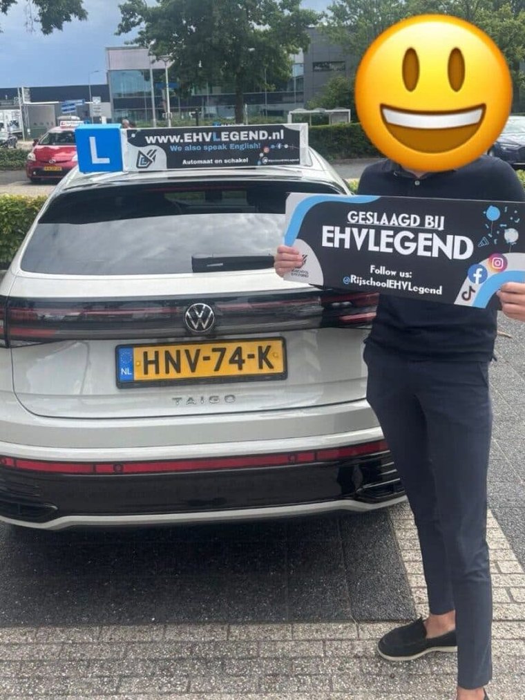 Geslaagde leerling met het GESLAAGD-bord van EHVLegend bij de lesauto