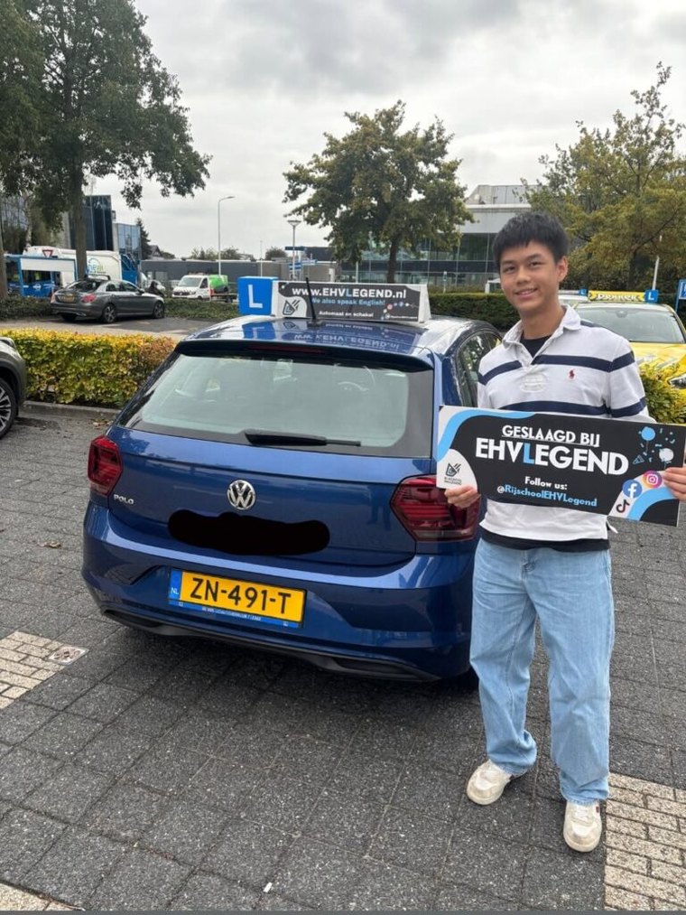 Geslaagde leerling bij de blauwe Volkswagen-lesauto van EHVLegend