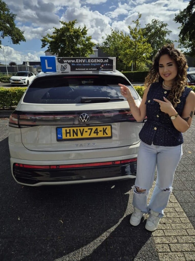 Geslaagde leerling trots naast de lesauto van Rijschool EHVLegend in Eindhoven